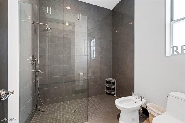 bathroom with an enclosed shower, toilet, and a bidet