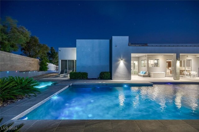 pool at twilight with a patio area