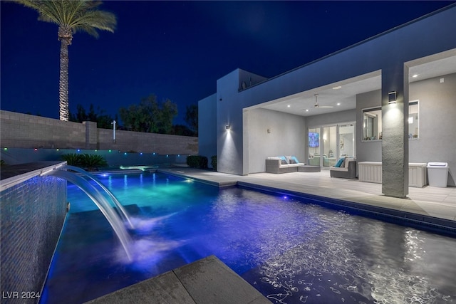 pool at twilight with ceiling fan, outdoor lounge area, a patio, and pool water feature