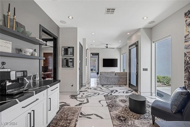 kitchen with ceiling fan, white cabinetry, a healthy amount of sunlight, and light tile patterned floors