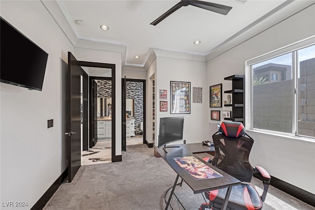 home office featuring ceiling fan, crown molding, and light carpet