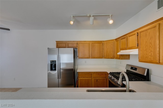 kitchen featuring stainless steel appliances, sink, and rail lighting