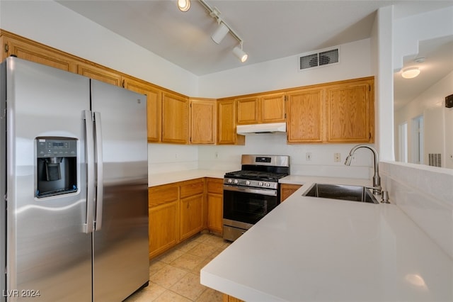 kitchen featuring light tile patterned floors, sink, kitchen peninsula, track lighting, and stainless steel appliances