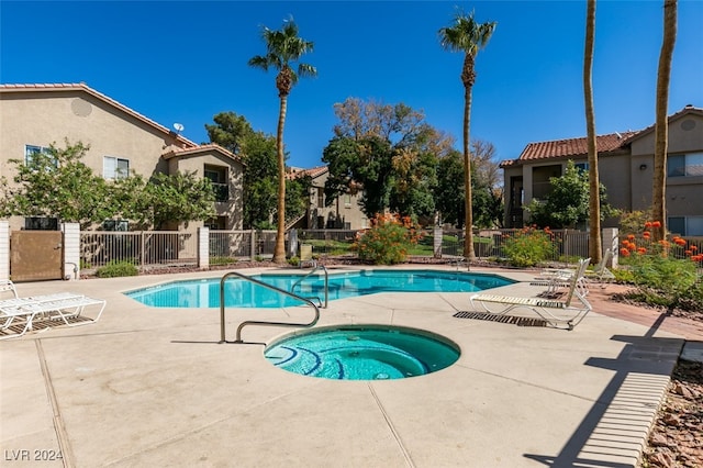 view of swimming pool featuring a hot tub and a patio