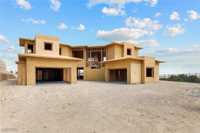 back of house with an attached garage and stucco siding