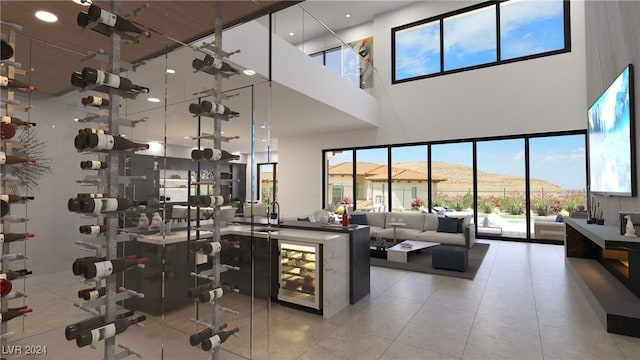 wine area with tile patterned flooring, a high ceiling, and recessed lighting