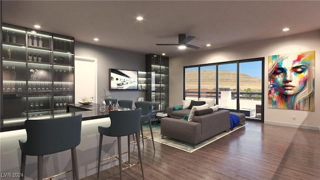 living room featuring ceiling fan and dark wood-type flooring