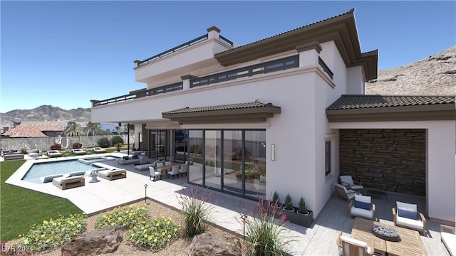 rear view of property with a patio area, a mountain view, a fenced in pool, and stucco siding