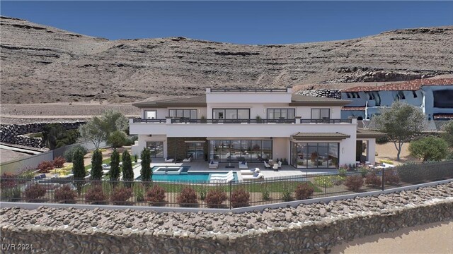 back of property featuring a balcony, a fenced in pool, and a patio