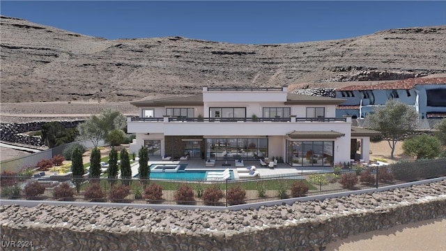 rear view of house featuring a balcony, fence, a mountain view, and a patio