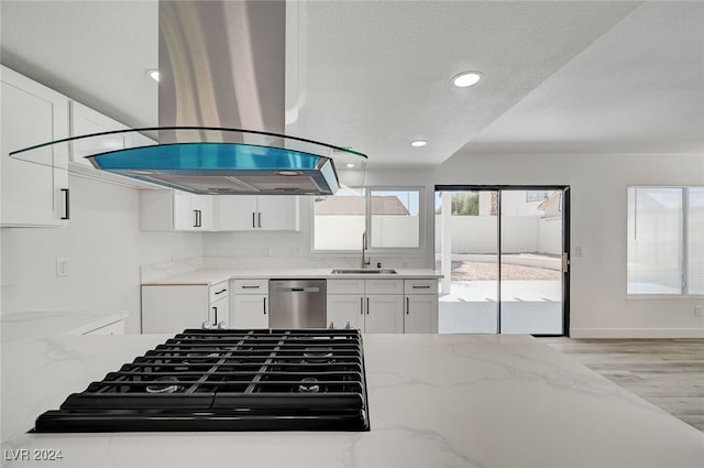 kitchen with sink, light wood-type flooring, light stone counters, stainless steel dishwasher, and island exhaust hood