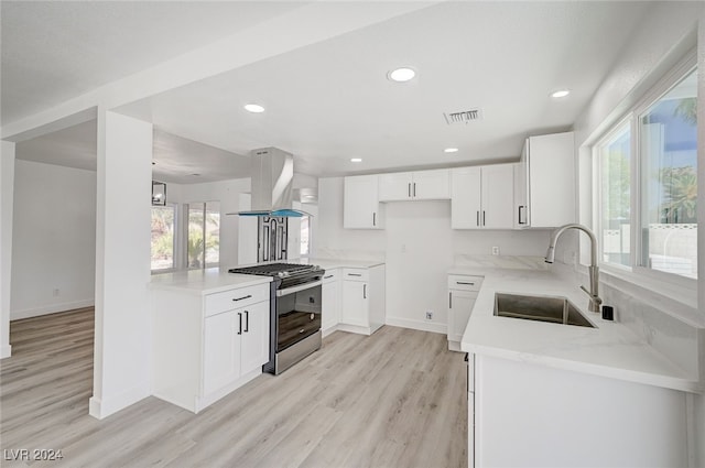 kitchen featuring light wood-type flooring, sink, stainless steel stove, and island range hood