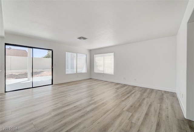 unfurnished room featuring plenty of natural light and light hardwood / wood-style flooring