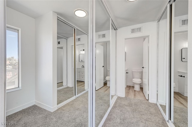 bathroom with toilet and hardwood / wood-style flooring