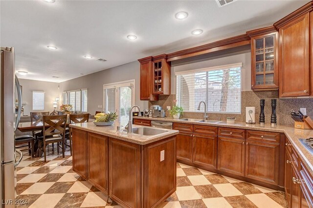 kitchen featuring sink, decorative backsplash, plenty of natural light, and a center island