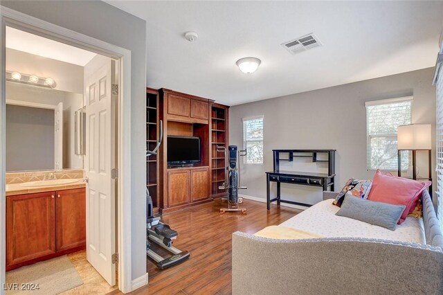 interior space featuring sink, ensuite bathroom, and light hardwood / wood-style flooring