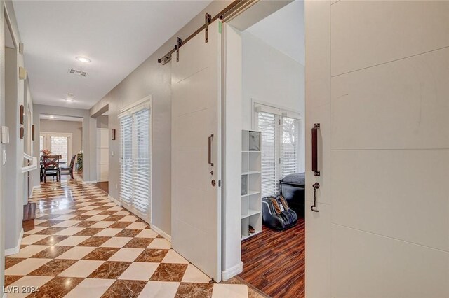 corridor featuring light tile patterned floors and a barn door