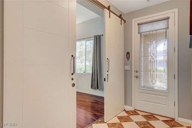 entrance foyer featuring light tile patterned floors and a barn door