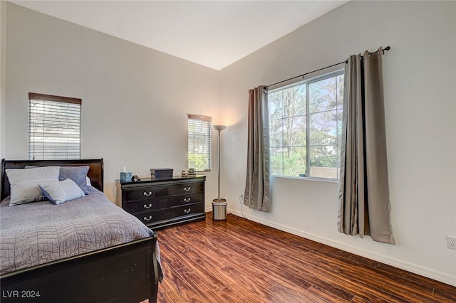 bedroom with vaulted ceiling and dark hardwood / wood-style flooring