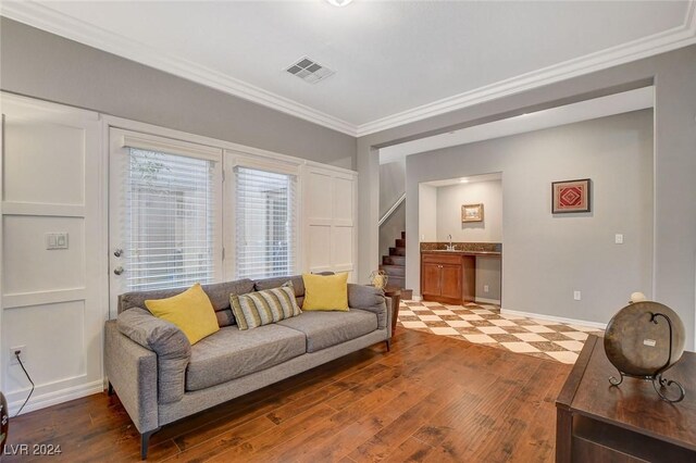 living room featuring sink, ornamental molding, and hardwood / wood-style flooring