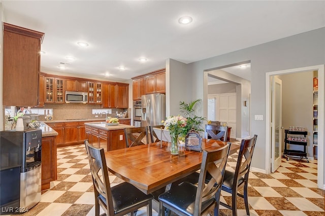 dining area featuring sink and light tile patterned flooring