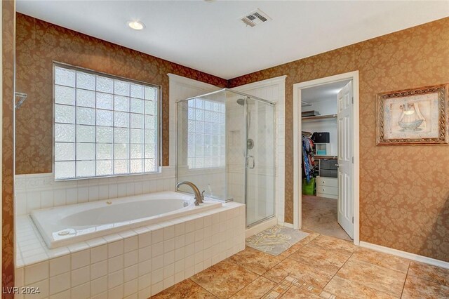 bathroom featuring tile patterned flooring and separate shower and tub