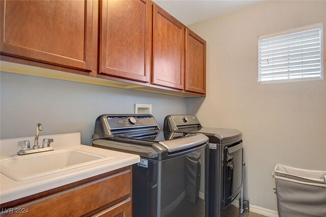 laundry room featuring sink, separate washer and dryer, and cabinets