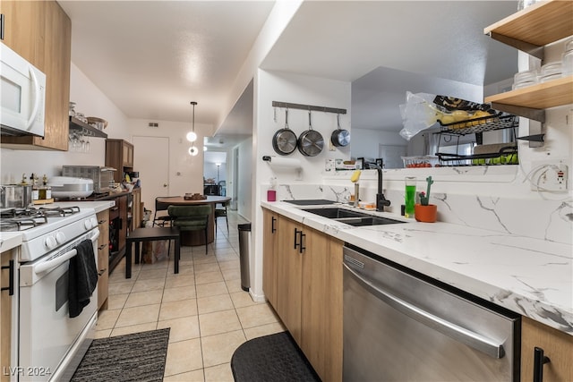 kitchen featuring sink, light stone countertops, light tile patterned floors, white appliances, and hanging light fixtures