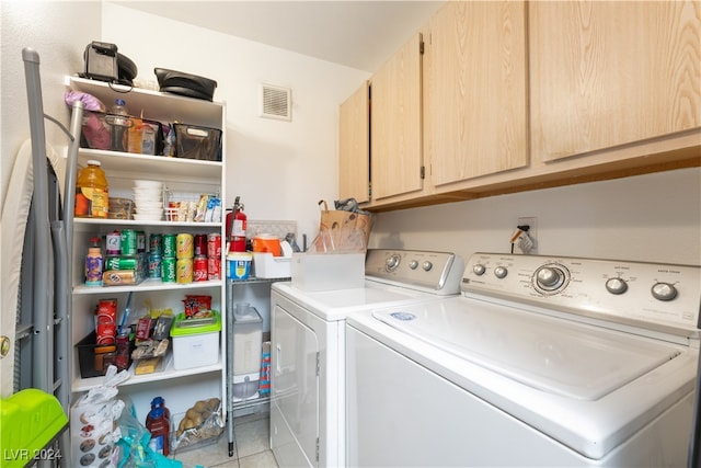 washroom featuring light tile patterned floors, separate washer and dryer, and cabinets