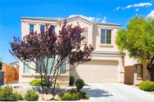 view of front facade with concrete driveway, an attached garage, fence, and stucco siding