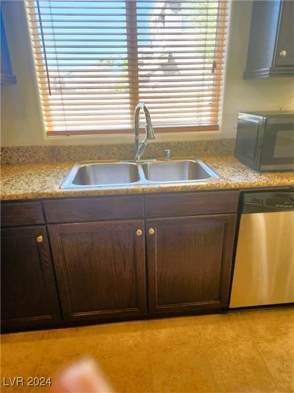 kitchen featuring a sink, dark brown cabinetry, dishwasher, and light tile patterned flooring