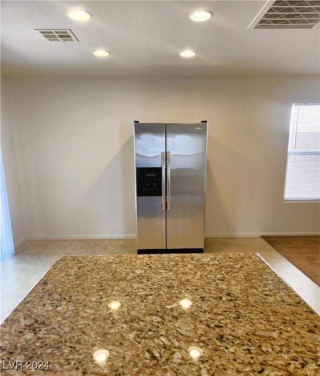 kitchen with stainless steel fridge, visible vents, light stone counters, and recessed lighting