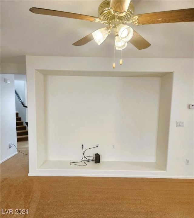 interior space featuring carpet floors, ceiling fan, and baseboards