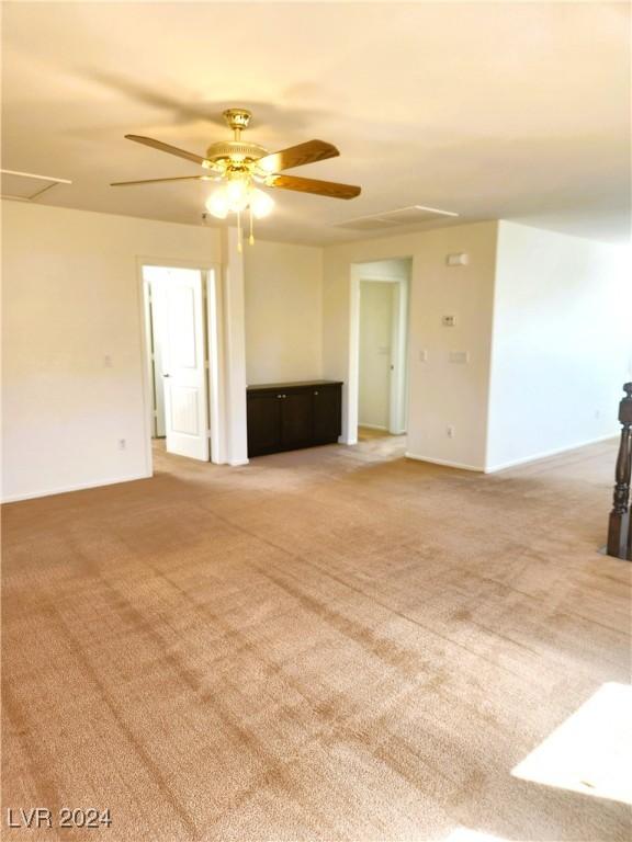 empty room with light colored carpet and ceiling fan