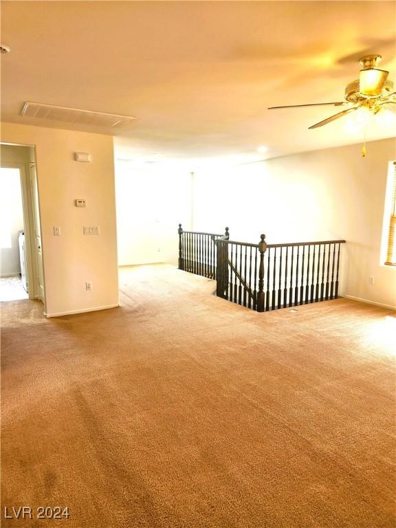 spare room with ceiling fan, carpet flooring, and baseboards