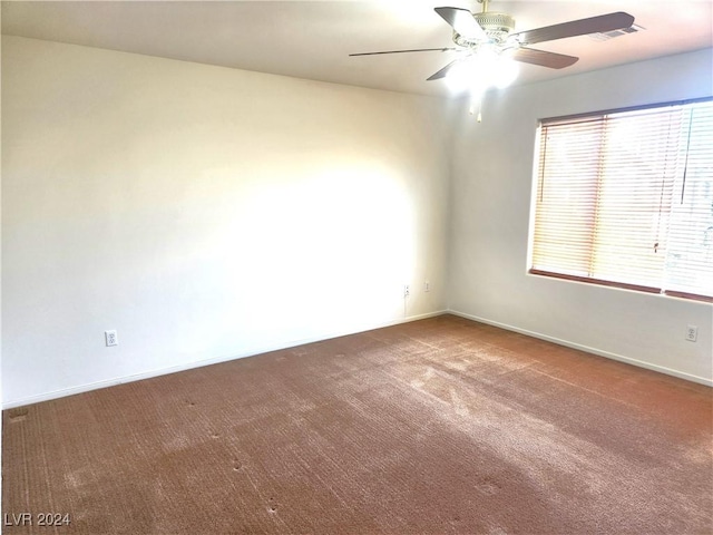 unfurnished room with carpet, visible vents, ceiling fan, and baseboards