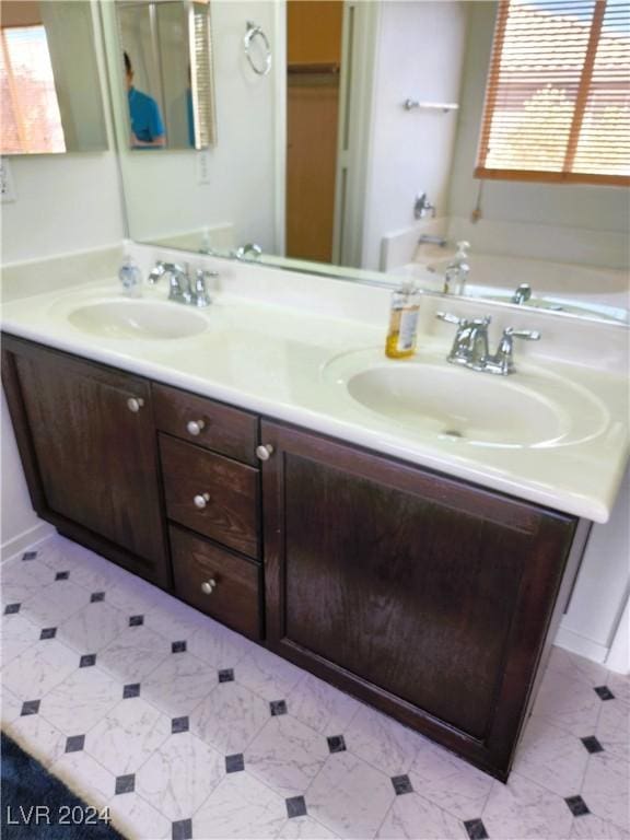 full bathroom with a garden tub, double vanity, and a sink