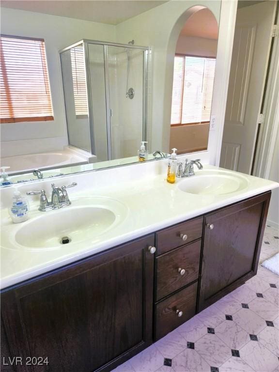 bathroom with double vanity, a stall shower, a sink, and a bath