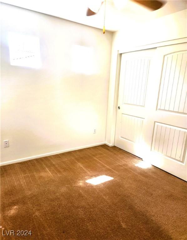 carpeted spare room with baseboards and a ceiling fan