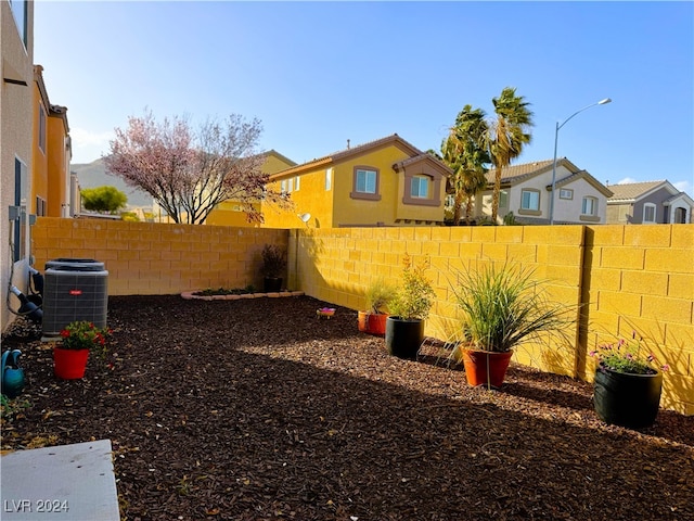 view of yard with central AC unit and a fenced backyard