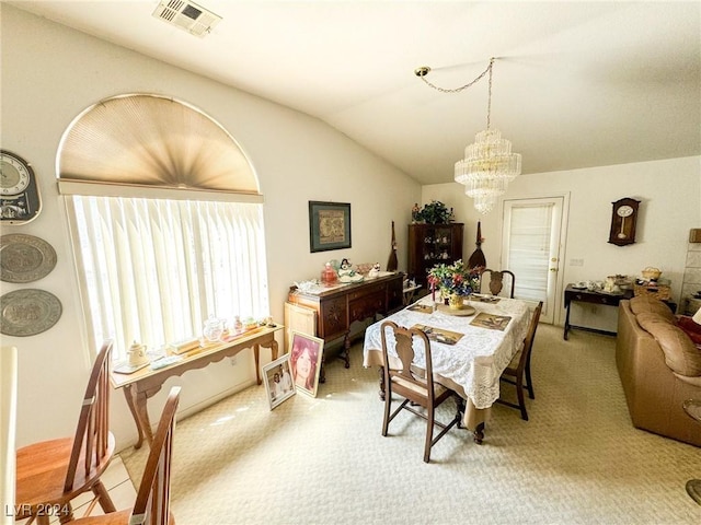 dining area featuring lofted ceiling, light carpet, and a notable chandelier