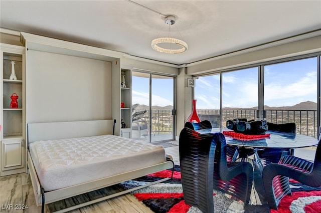 bedroom featuring multiple windows, light hardwood / wood-style flooring, and access to outside