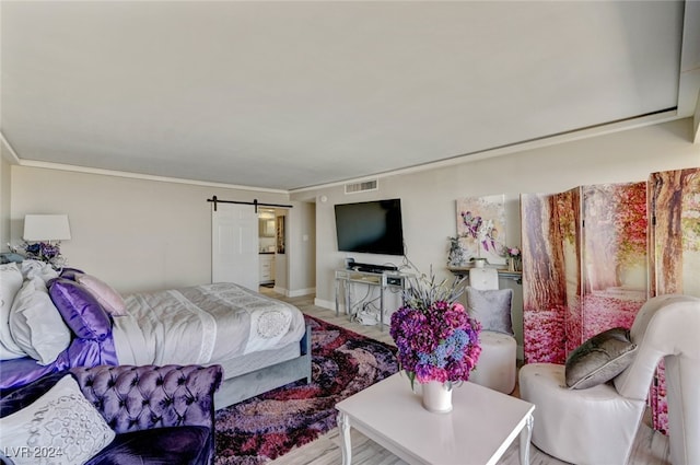 bedroom with crown molding and a barn door