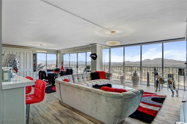 living room featuring expansive windows, a mountain view, and light hardwood / wood-style floors