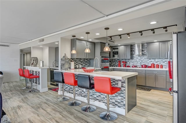 kitchen with backsplash, a kitchen breakfast bar, appliances with stainless steel finishes, and kitchen peninsula