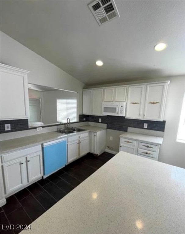 kitchen with white cabinets, sink, and dishwashing machine