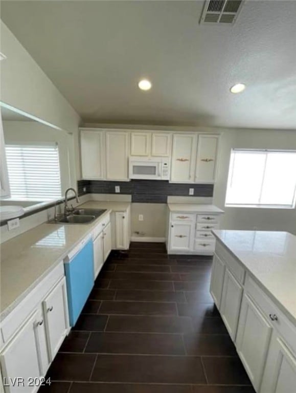 kitchen with white cabinetry, sink, and white appliances