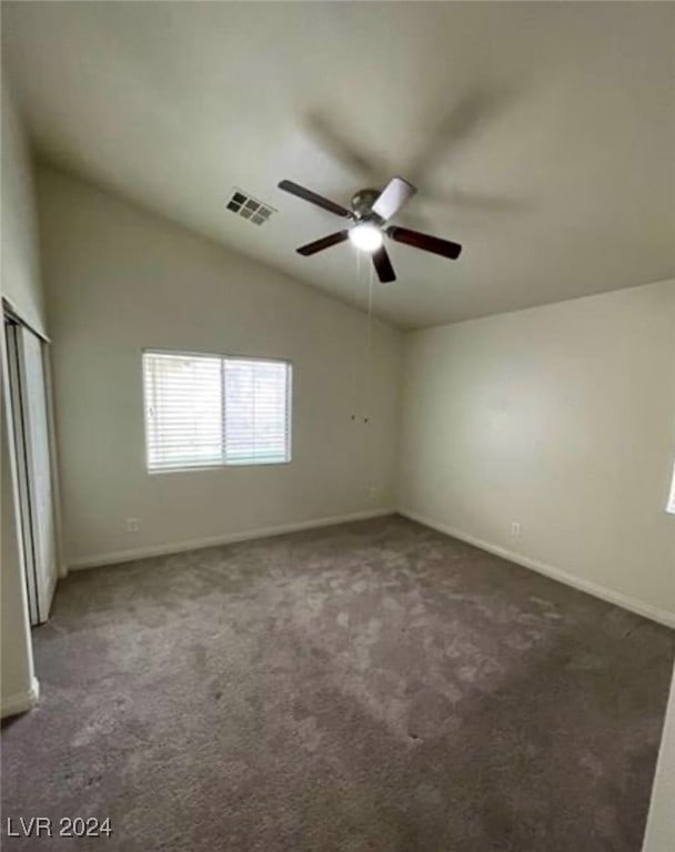 carpeted spare room featuring ceiling fan and lofted ceiling