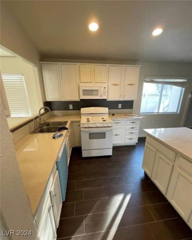 kitchen with sink, white appliances, and white cabinets