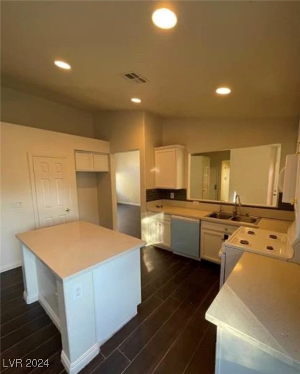 kitchen featuring dishwasher, white cabinetry, dark hardwood / wood-style floors, sink, and a center island